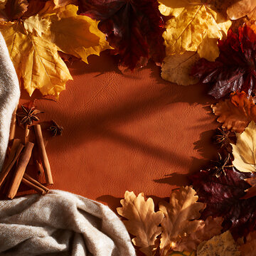 Colorful autumn leaves and spices on a textured background create a seasonal setting
