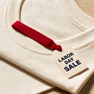Labor day sale tag on a plain shirt displayed on a table