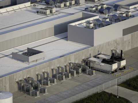 Aerial view of the DeKalb Data Center featuring industrial cooling systems and HVAC units on the roof and ground level in DeKalb, Illinois, United States.