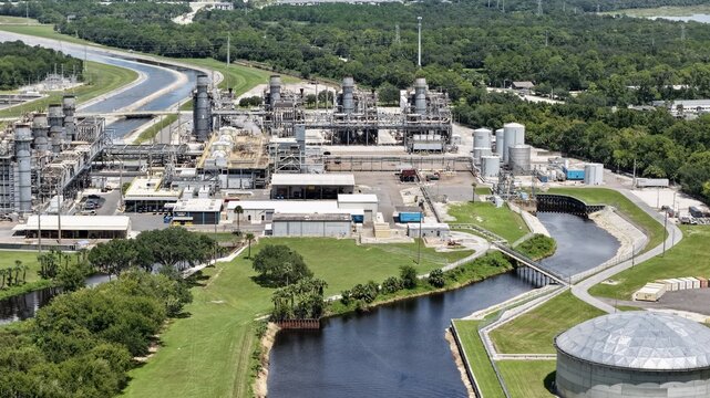 Aerial view of FPL Sanford Power Plant with its industrial infrastructure, cooling towers, storage tanks, and surrounding canals in DeBary, Florida, United States.