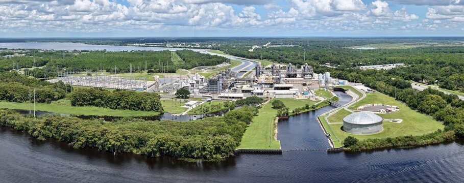Aerial view of FPL Sanford Power Plant situated along the St. Johns River, featuring industrial infrastructure, storage tanks, and surrounding lush greenery in DeBary, Florida, United States.