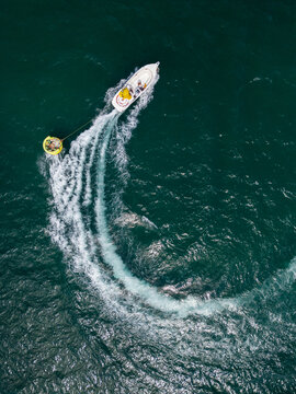 Aerial View of Speedboat Towing Inflatable Tube on Deep Blue Sea