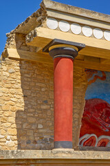 Naklejka premium A reconstructed section of the Palace of Knossos on Crete, Greece, featuring the characteristic red Minoan columns, decorated architectural elements and a colorful bull fresco.