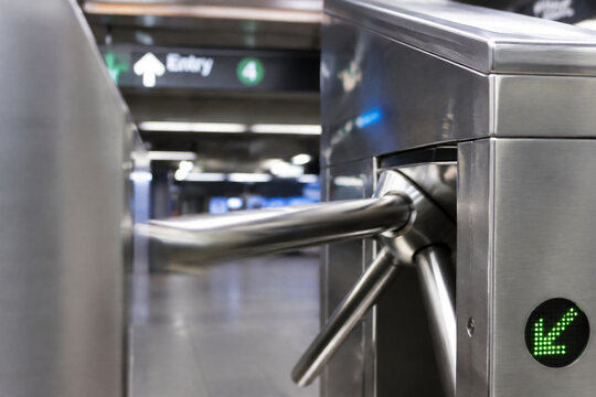 Close-up of a stainless steel turnstile arm rotating at a subway entrance, clean surfaces.