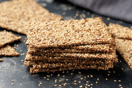 Wholegrain Crispbread with Sesame and Flax Seeds on Dark Surface