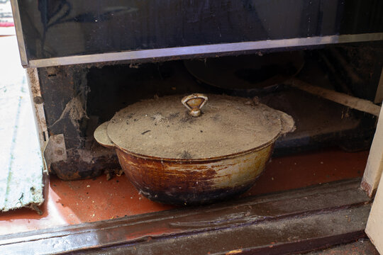 Dusty pot hiding in a forgotten kitchen corner, showcasing layers of time and neglect