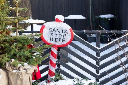 Santa stop here sign with Christmas tree and snow outdoors in daylight