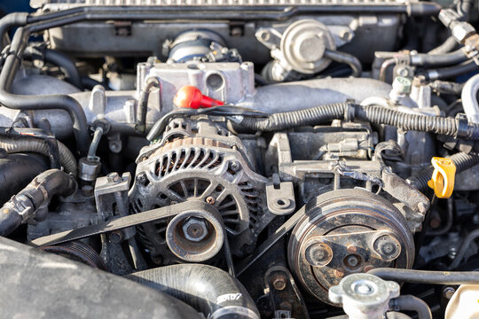 Close-up of car engine with alternator, belts and mechanical components