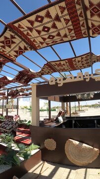 Traditional Arabic outdoor tea and coffee cafe shaded by patterned fabrics.