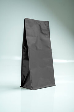 Matte black coffee bag mockup standing on a white background, ideal for packaging design presentation. Mockup or Copyspace