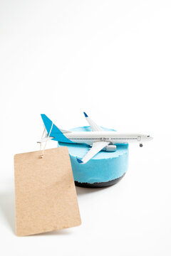 Toy airplane on a blue stand with a blank cardboard tag against a white background. Mockup or Copyspace