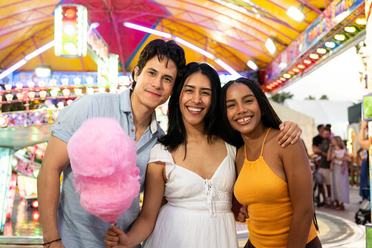 Group of diverse friends enjoying an evening together at a funfair
