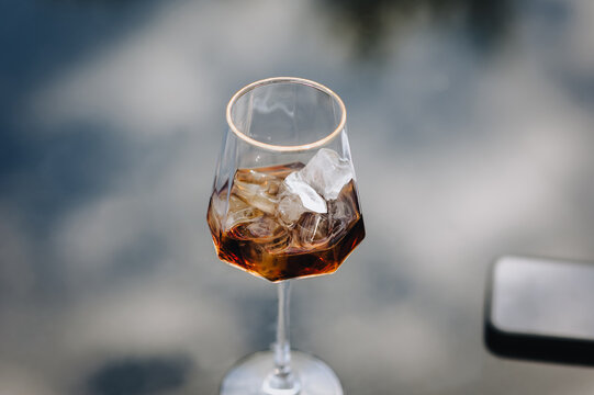 Close-up photo of a wine glass with a chilled alcoholic cocktail on ice.