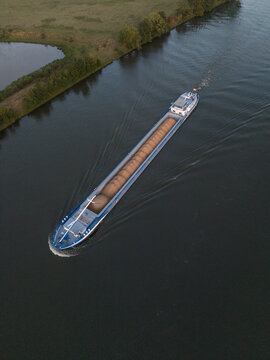 Aerial view of a cargo ship transporting bulk goods along a river in The Netherlands.