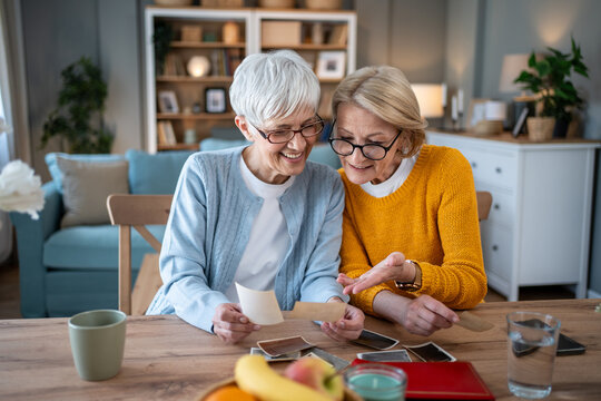 Senior women friends looking at old photographs