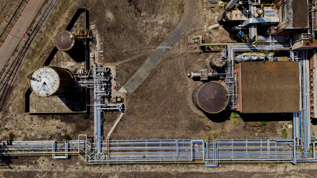 Aerial view of the petrochemicals industry facility featuring large storage tanks, intricate networks of industrial piping, and factory buildings in Pancevo, Serbia.