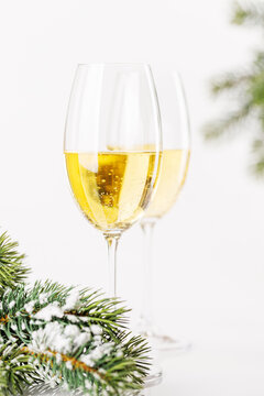 Champagne glasses and snowy fir on white