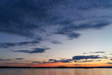 Obraz premium Dramatic twilight sky over river horizon