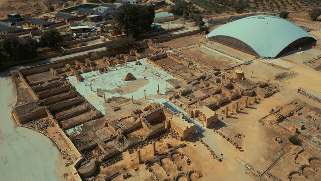 Aerial view of Hisham's Palace, an Umayyad-era archaeological site featuring stone ruins, columns, and a modern protective dome structure in Jericho, West Bank, Palestine.