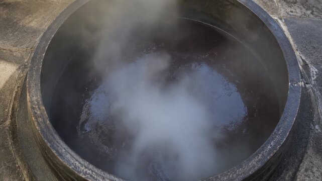 Steaming Traditional Dark Broth Simmering in Large Cauldron