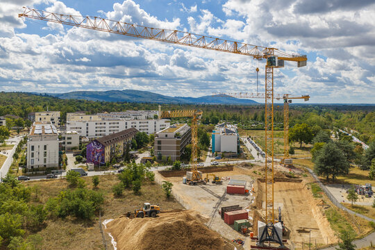 Aerial view of Lincolnsiedlung construction site featuring tower cranes, excavation work, and modern residential buildings in Darmstadt, Hessen, Germany.