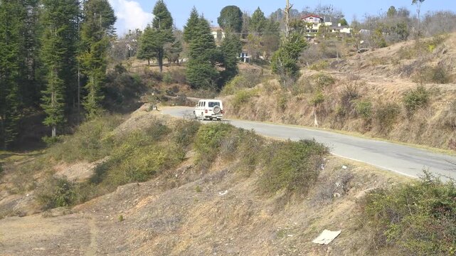 White Utility Vehicle Driving Toward Khetikhan on Winding Hill Road Near Lohaghat, Uttarakhand