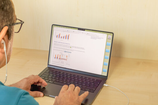 At his laptop in the office. Screenshot of him reviewing a chart.