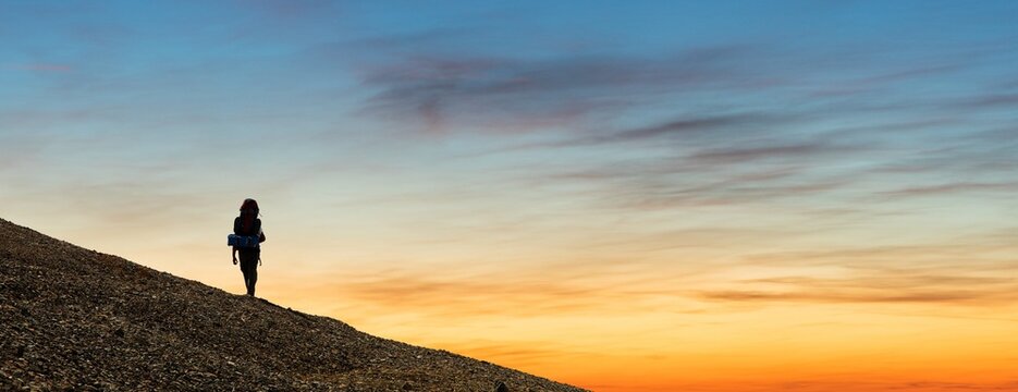 climber or hiker or tourist on sunset sky background