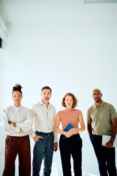 Diverse business team of professionals standing in a modern office, representing teamwork, leadership, and success