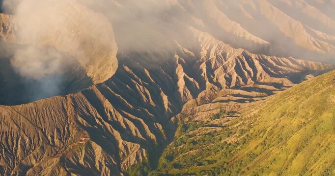 Aerial view of Mount Bromo and Tengger Caldera showing volcanic craters, rugged ridges, and golden morning light in Indonesia.