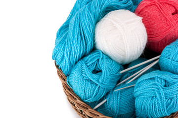 Balls of yarn in a basket with knitting needles, isolated on white background . © kuzina1964