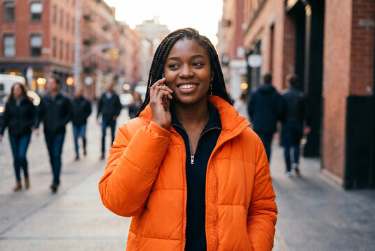 African American young woman talking on phone in urban street