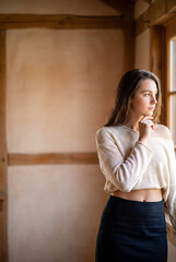 Fototapeta premium Young Caucasian woman gazing thoughtfully in minimalist wooden interior