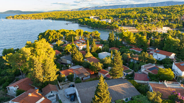 High angle drone shot displays stunning coastal landscape of Hvar Island. Panorama includes historic Stari Grad port