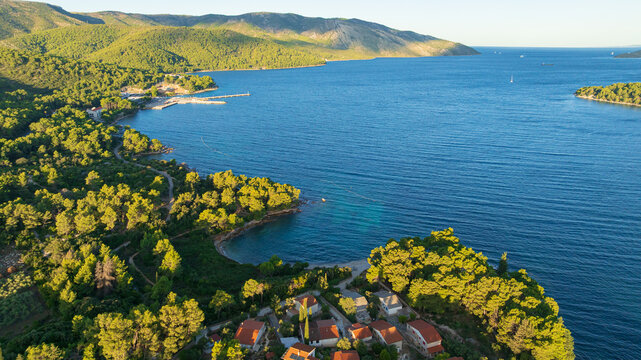 High angle drone shot displays stunning coastal landscape of Hvar Island. Panorama includes historic Stari Grad port