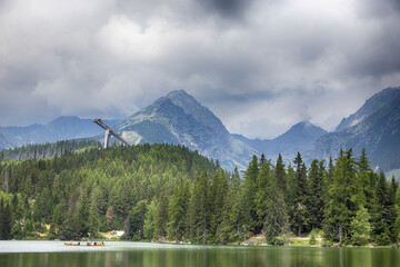 Alpenberg mit dichtem Nadelwald und Skisprungschanze im Nebel © tamaslaza3