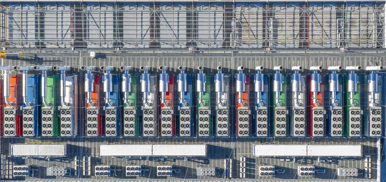 Aerial view of industrial HVAC cooling units arranged in rows on a rooftop with colorful equipment casings in Offenbach am Main, Hessen, Germany.