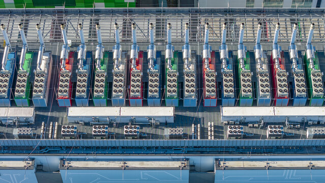 Aerial view of rows of colorful industrial HVAC units and ventilation systems on a flat rooftop in Offenbach am Main, Hessen, Germany.