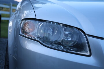 Close up of a modern car headlight. Close-up detail of a modern automobile headlight, showcasing automotive lighting, vehicle design and exterior details. © Photo Image 555
