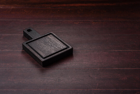 A square wooden cutting board for home food preparation. A wooden cutting board