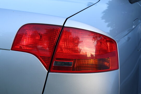 Close up of a modern car taillight with red rear light. Close-up detail of a modern automobile taillight with red rear lighting, showcasing automotive design, vehicle technology and exterior details.