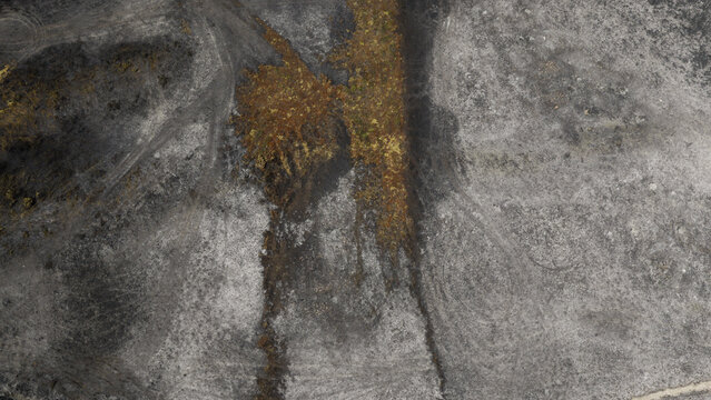 Aerial view of burnt landscape showing fire damage with scorched earth and patches of vegetation in Plevenon, Brittany, France.