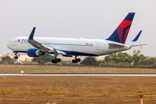 Luqa, Malta - August 29, 2206: Delta Air Lines Boeing 767-332/ER (REG: N188DN) with an unusually orange sky due to Saharan desert sand present in the atmosphere.
