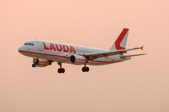 Luqa, Malta - August 29, 2206: Lauda Europe Airbus A320-214 (REG: 9H-LOU) landing in the early morning with an unusually orange sky due to Saharan desert sand present in the atmosphere.