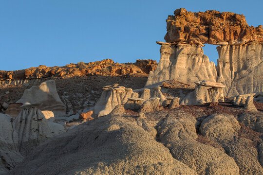 Beautiful scenic view of a unique natural stone arch rock formation in desert at sunset