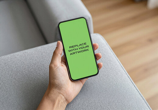 Smartphone screen mockup held in hand on grey fabric surface, green display with placeholder text, realistic mobile device presentation for app or website design, Template