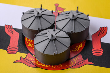 Liquefied gas storage tanks set against the Brunei flag, representing the concept of supply © chernikovatv