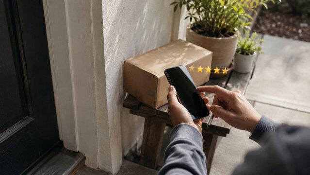 Customer Giving Five Star Rating on Smartphone After Package Delivery