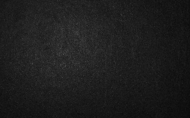 Dark black textured paper background or charcoal gray surface with fine grain. © Putu