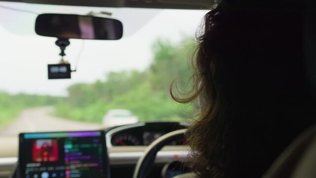 A female driver operates her vehicle on a rural road during a daytime trip, with a dashcam recording the journey from an interior passenger perspective.